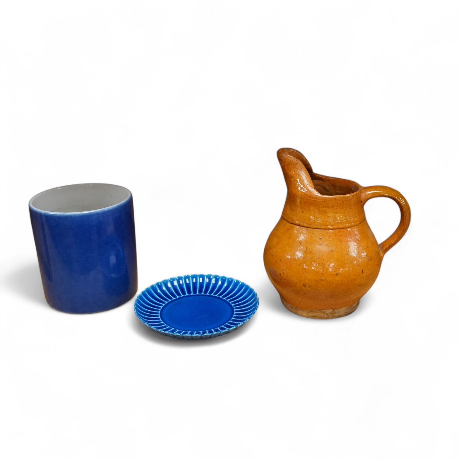 A Chinese blue glazed cylindrical brush pot, Kangxi mark but later, a similar saucer, Qianlong mark but later and a terracotta jug, 21cm